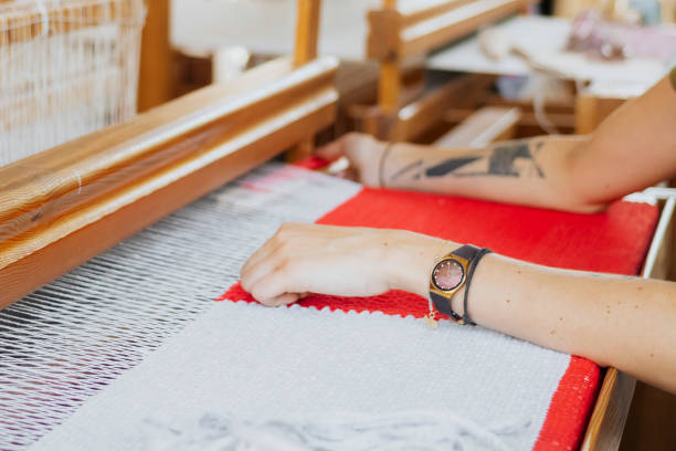 istock Woman weaving on a loom 2158050105