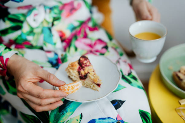 istock Woman eating orange with plum crumble pie 2158050228