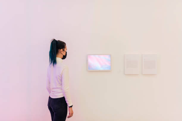 istock Girl looking at digital frames on a white gallery wall 2158051150
