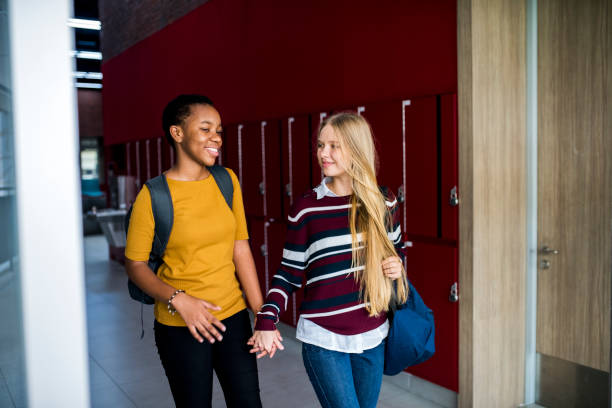 istock Girl students walking at school holding hands 2158051210