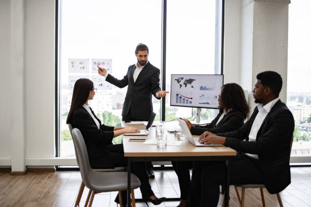 istock Business man giving presentation to multiracial colleagues in modern office 2158051265
