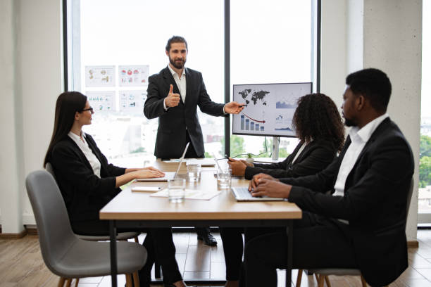 istock Businessman presenting sales report to colleagues in modern office 2158051285