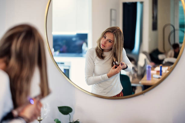 istock Young woman is making her hairstyle before going out. 2158051381