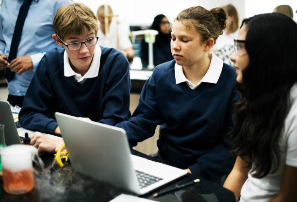 istock Group of diverse hight school students using laptop in science laboratory class 2158051539