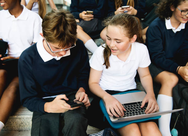 istock Group of students sitting on staircase using lptop 2158051545