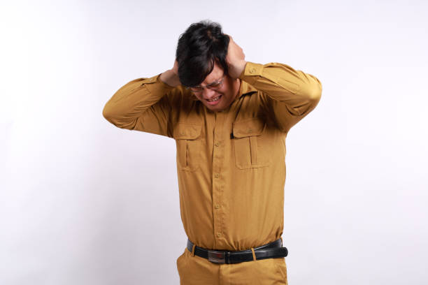 istock Young Indonesian government employees suffering from headache desperate and stressed because pain and migraine. Hands on head. 2158057405