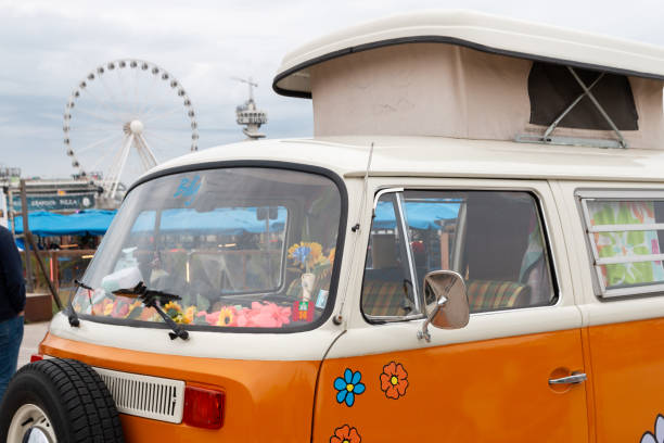 Scheveningen beach, the Netherlands - May 26, 2024: Orange VW kombi camper wagen parked near scheveningen pier
