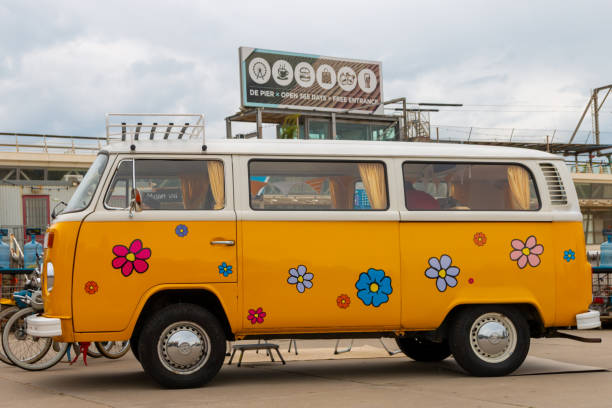 Scheveningen beach, the Netherlands - May 26, 2024: Bright yellow VW kombi camper wagen with flower pattern  at Aircooled classic car show