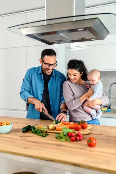 istock Dad cooking in the kitchen with mom and baby 2158057483