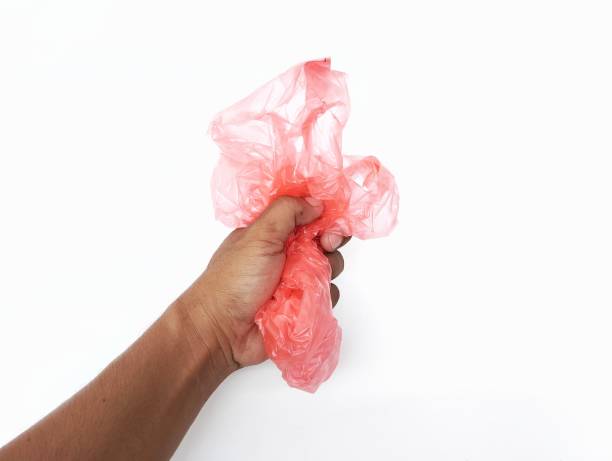 istock Hand man holding a crumpled red plastic bag isolated in white background 2158058064