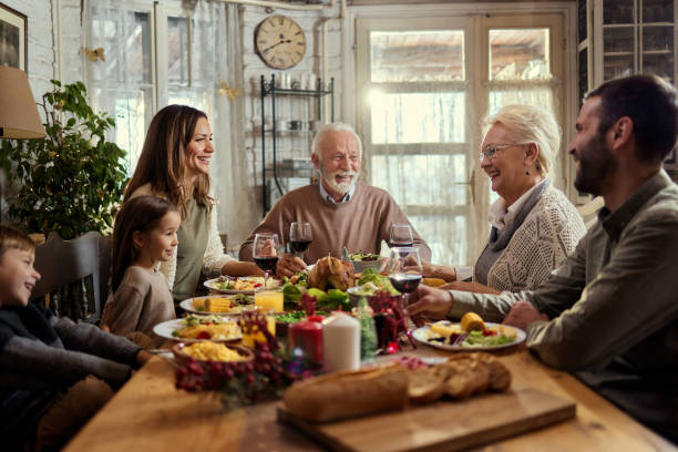 istock Happy multi-generation family enjoying in conversation during a meal at dining table. 2158059198