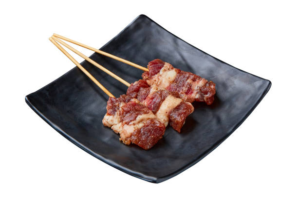 istock 3 Dry-aged beef that has been marinated and skewered and prepared for grilling and served on a black plate isolated on white background. 2158059856