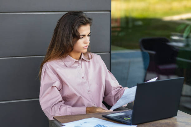 istock Businesswoman working on laptop outdoors in cafe 2158060072