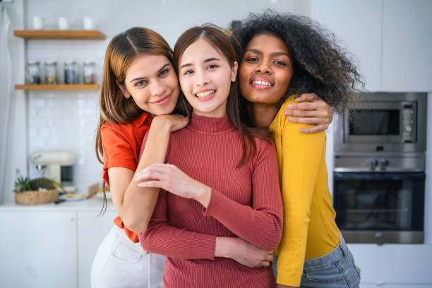 istock Three women are hugging each other in a kitchen 2158061750