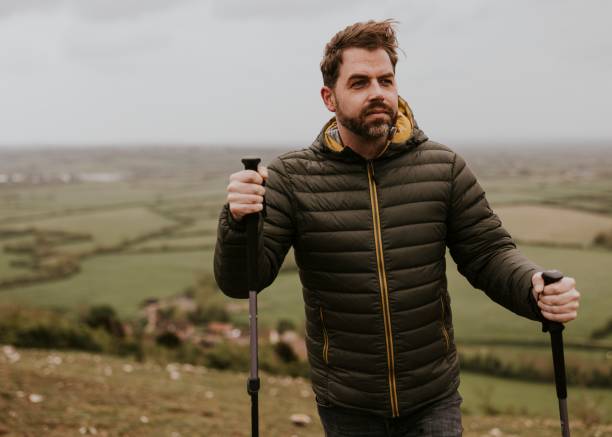 istock Man wearing jacket, holding hiking pole 2158061988