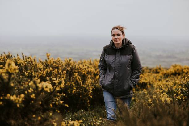 istock Woman wearing jacket walking in flower field 2158062336