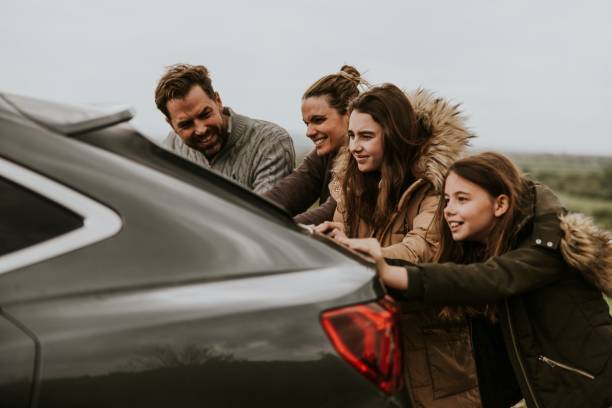 istock Family pushing broken car photo 2158063141