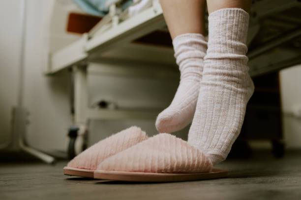 istock Woman Trying to Put On Slippers 2158065739