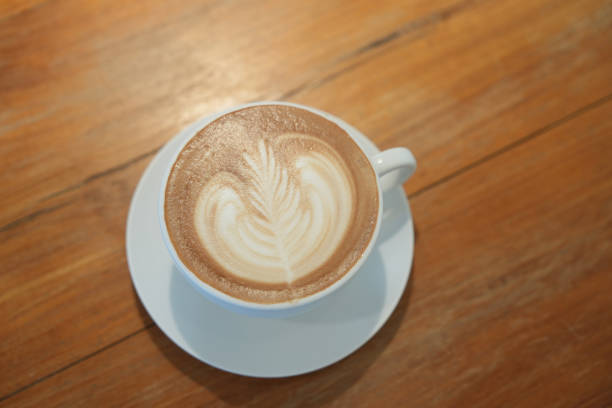 istock Hot latte art coffee in white ceramic cup on wooden table. 2158066889