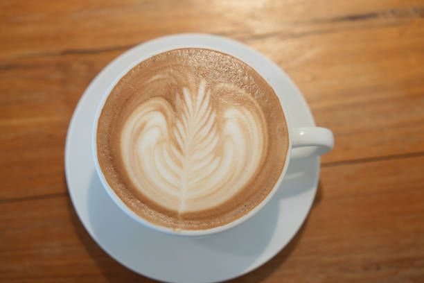 istock Hot latte art coffee in white ceramic cup on wooden table. 2158066891