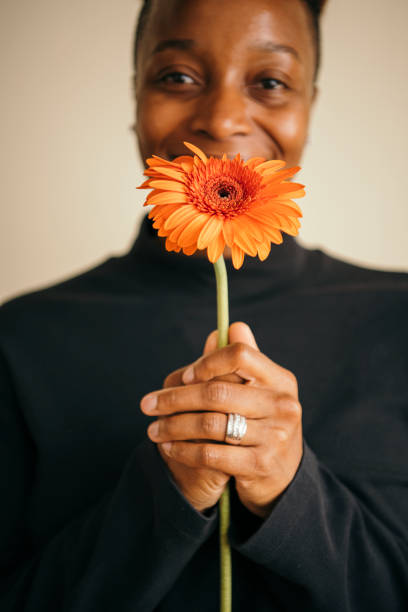 istock Happy black woman holding a daisy flower 2158069294