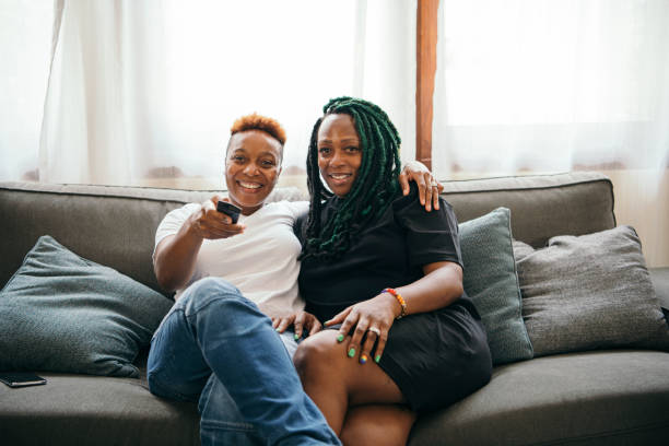 istock Happy lesbian couple watching the television together 2158069416