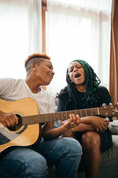 istock Happy lesbian couple playing the guitar and singing 2158069474
