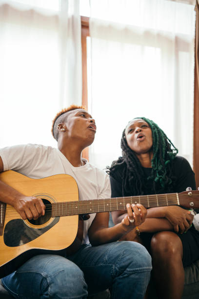 istock Happy lesbian couple playing the guitar and singing 2158069501