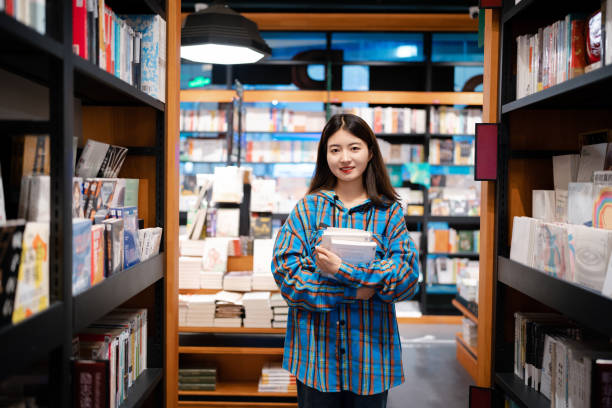 University  student buying books in bookstore at night