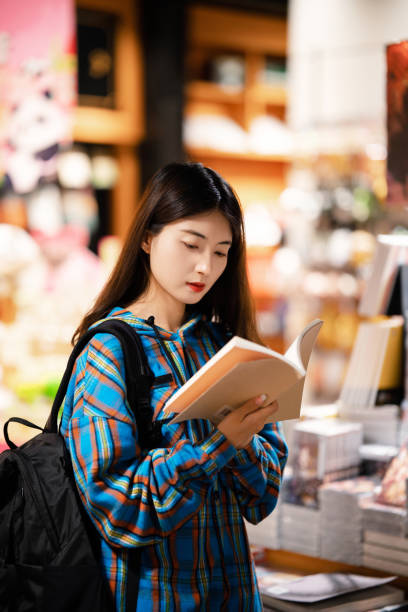 istock University  student buying books in bookstore at night 2158071393