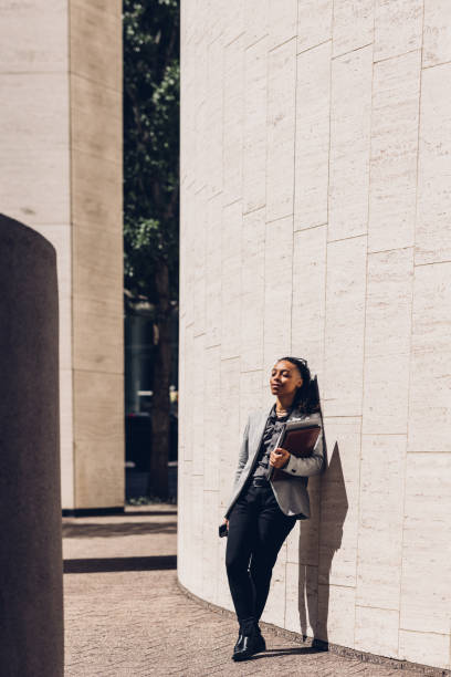 istock Confident Businesswoman Standing Outdoors Leaning Against Building Wall 2158071833