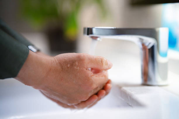 An adult man is washing his hands