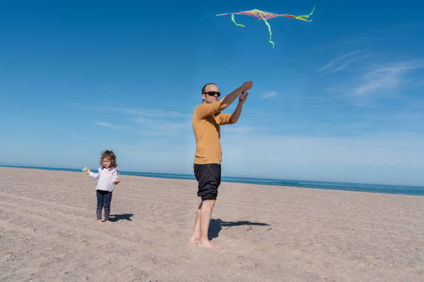 istock Father and Daughter Flying a Kite on the Beach 2158072314
