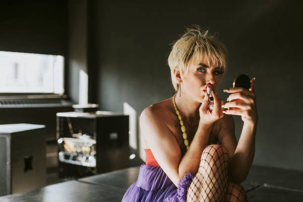 istock Man in drag applying lipstick, entertainment makeup look 2158072526