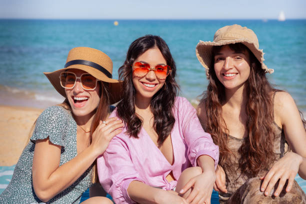 istock Three happy young friends on the beach on vacation, look at camera 2158074191