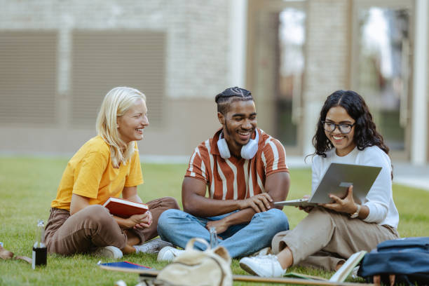 istock Group of students hanging out and discussing the school project while using laptop 2158076263