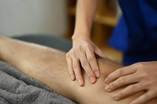 istock Closeup physiotherapist doing a patellar mobilization male patient. Physical therapy and rehabilitation concept 2158076893