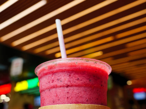 istock A cup of pink-red smoothie with a straw in a cafe 2158078806