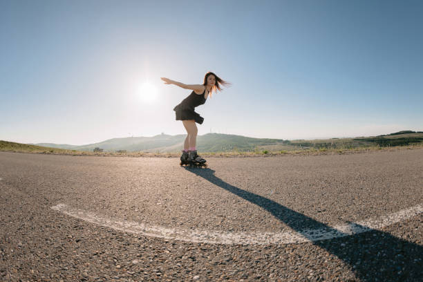 Young woman roller skating on road, leisure activity