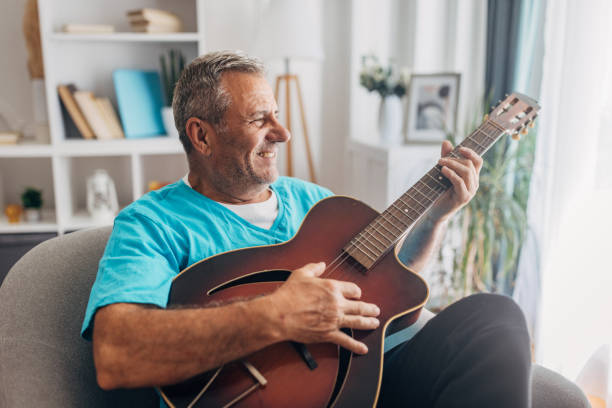 istock Elderly man playing acoustic guitar at home 2158081636