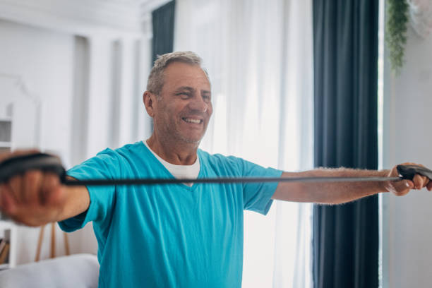 istock Senior man with resistance band in a home setting 2158085766