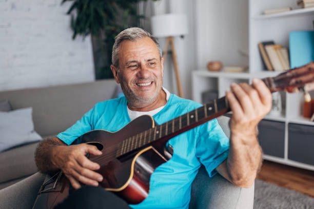 istock Older man with a guitar smiling joyfully 2158086094