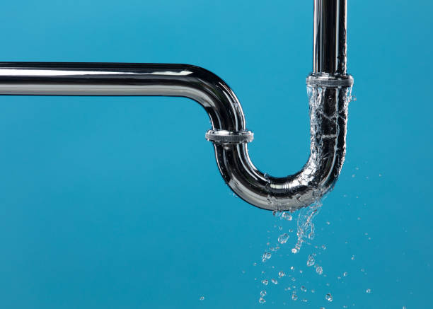 Leaking water from chromium stainless steel pipe under sink. Drain leak water from pipe plumbing in bathroom as water clogged drop. Blue bathroom background isolated