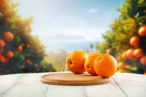 istock Fresh orange fruit on wooden board table  with blurred  fruit plantation background. 2158090009
