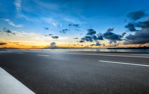 Empty asphalt road and cloudscape by the sea. Clean car road background