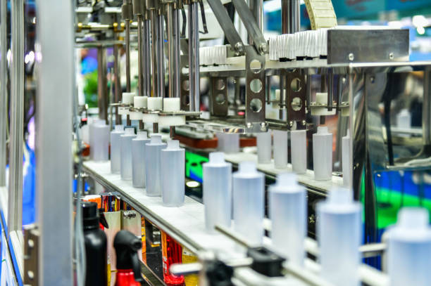 White plastic bottles in a conveyor belt on a high quality automatic vertical filling machine. in the factory production line