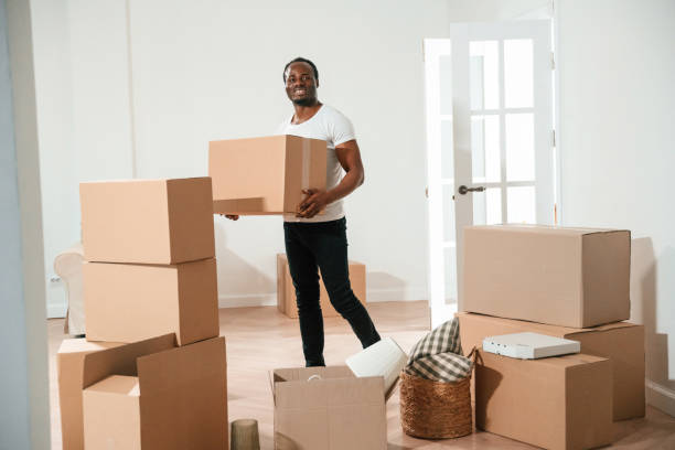 istock Happy black man is moving in his new home, holding box 2158091503