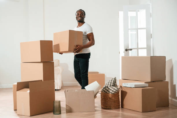 istock Happy black man is moving in his new home, holding box 2158091515