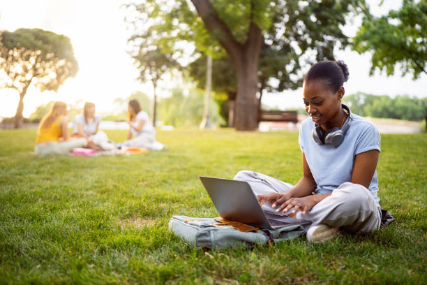 istock Young woman Black ethnicity, using the laptop for work or studying, while sitting on grass 2158092446