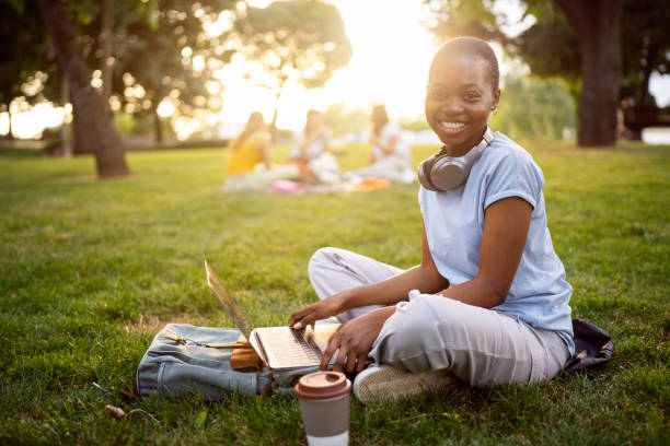 istock Portrait of a young woman Black ethnicity, using the laptop for work or studying, while sitting on grass 2158092475